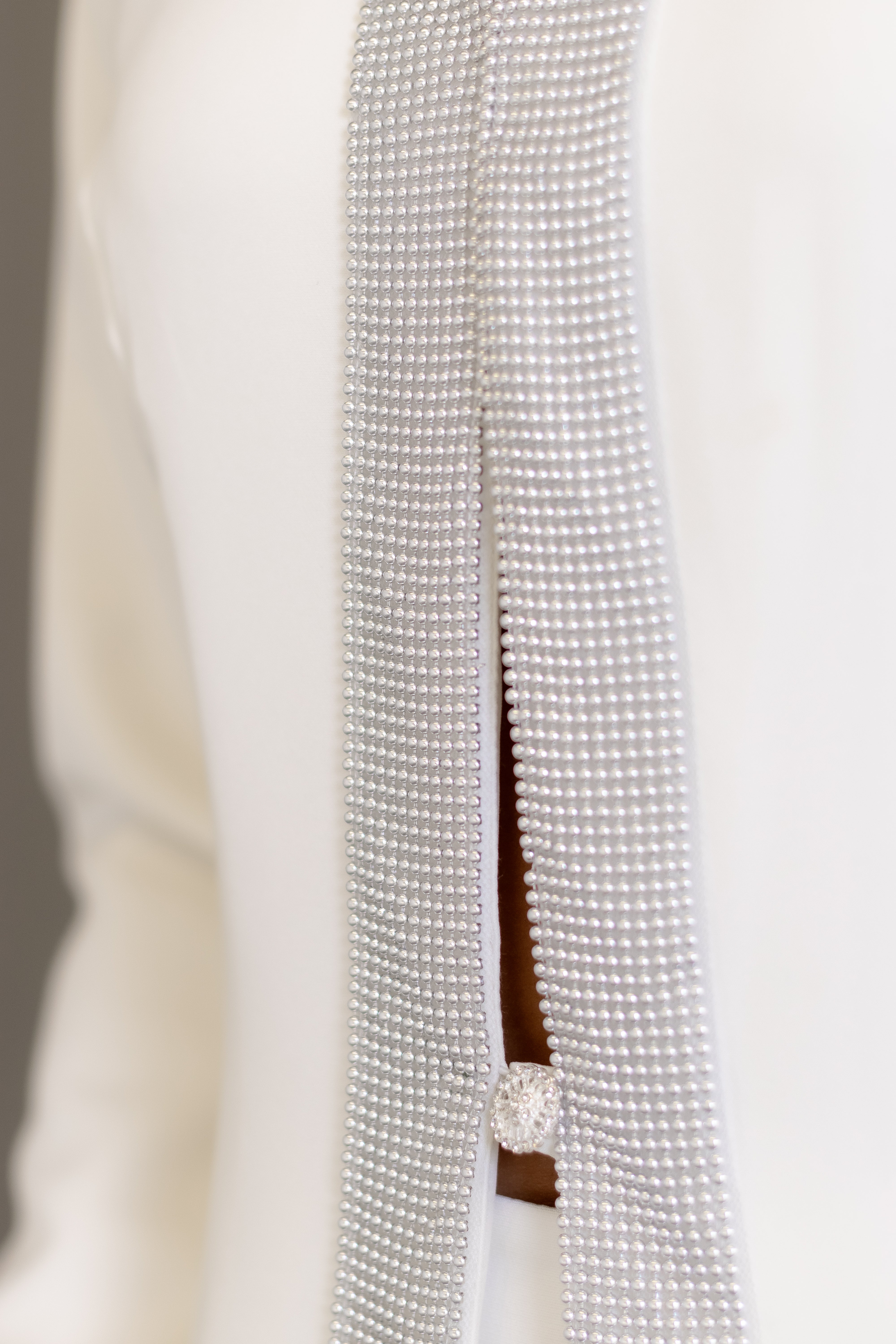 Jaleca Premium Aubrey: jaleco feminino elegante em branco, com aplicações brilhantes.