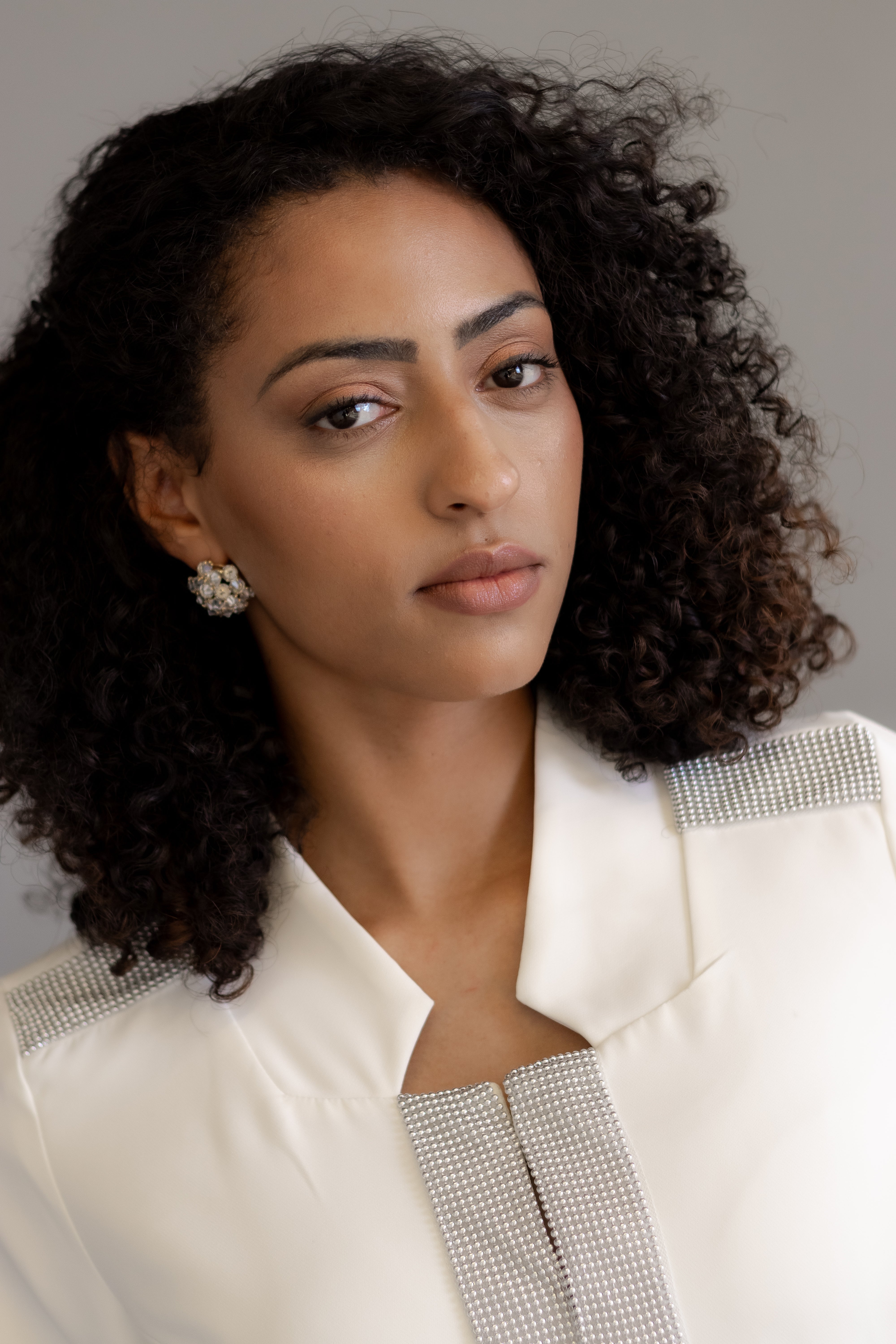 Jaleca Premium Aubrey: jaleco feminino elegante em branco, com aplicações brilhantes.